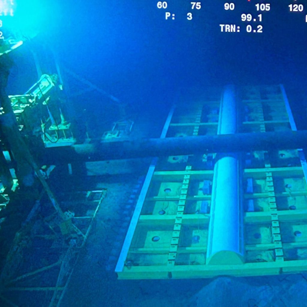 Pipe lift frame and mattress subsea supporting a live pipeline.