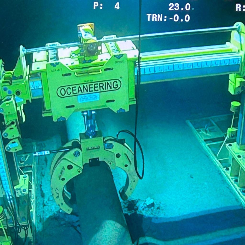 Pipe lift frame lifting and positioning live subsea pipeline.