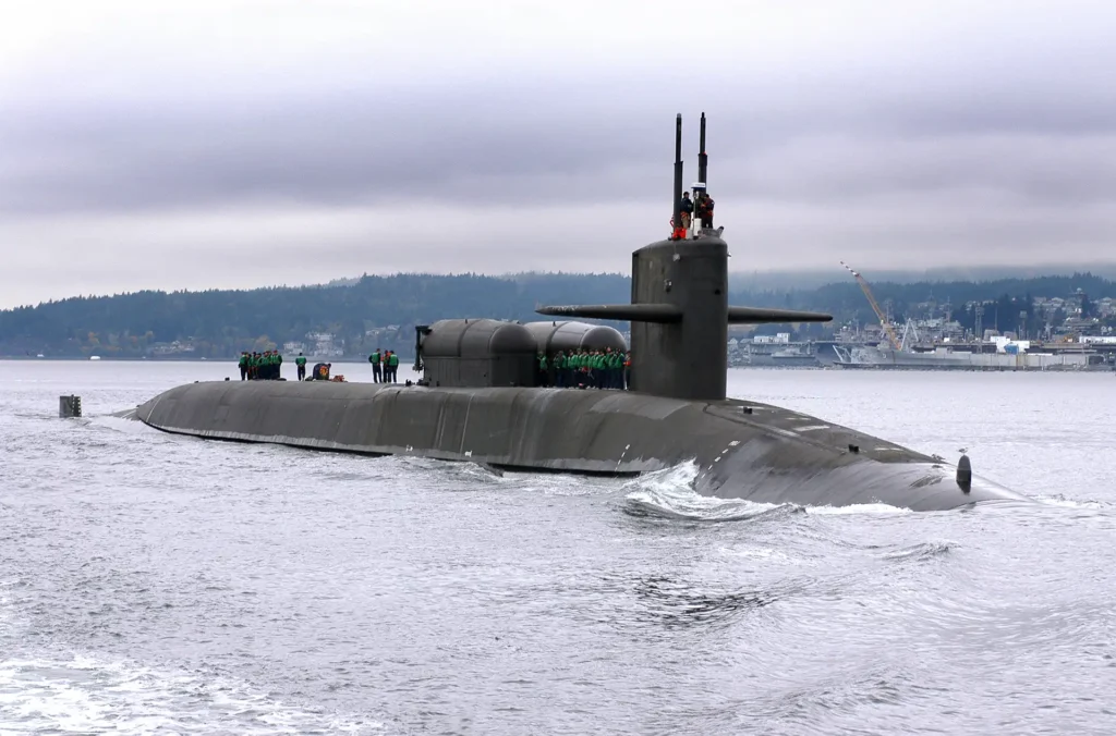 Ohio class submarine partially submerged with sailors topside