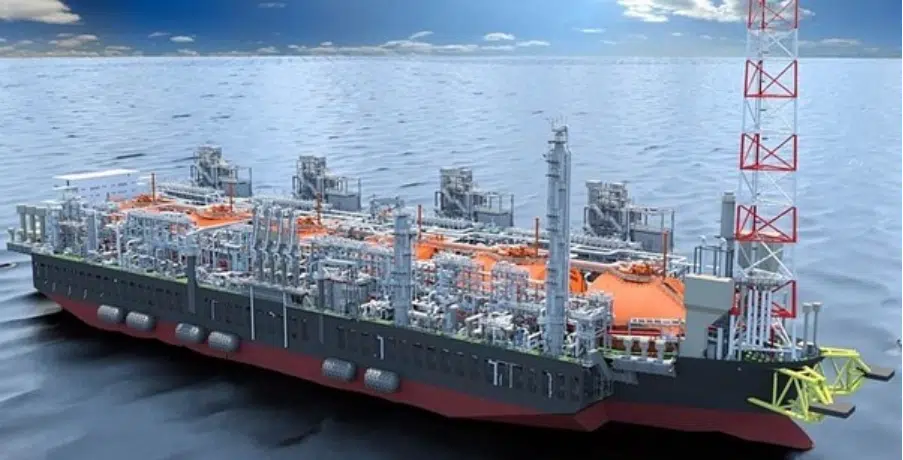 Floating liquefied natural gas FLNG production vessel at sea featuring extensive processing equipment storage tanks and a flare tower on the deck shown in an offshore marine environment