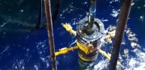 Subsea inclinometer tool suspended above the ocean during an offshore deployment operation.