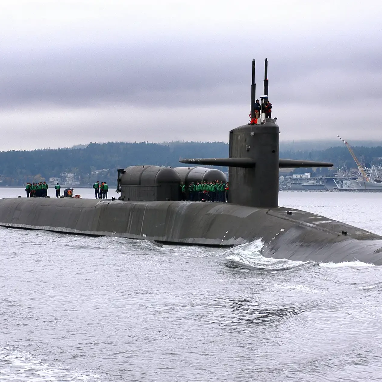 Ohio class submarine partially submerged with sailors topside